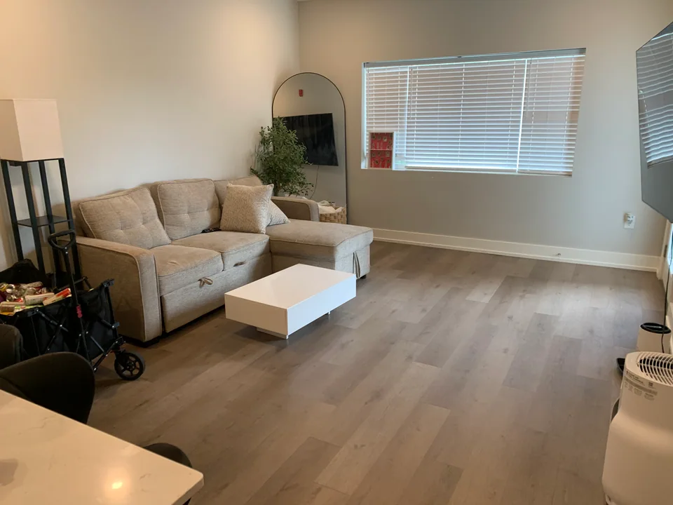 Living room with a gray sectional, white coffee table, and clear floor.